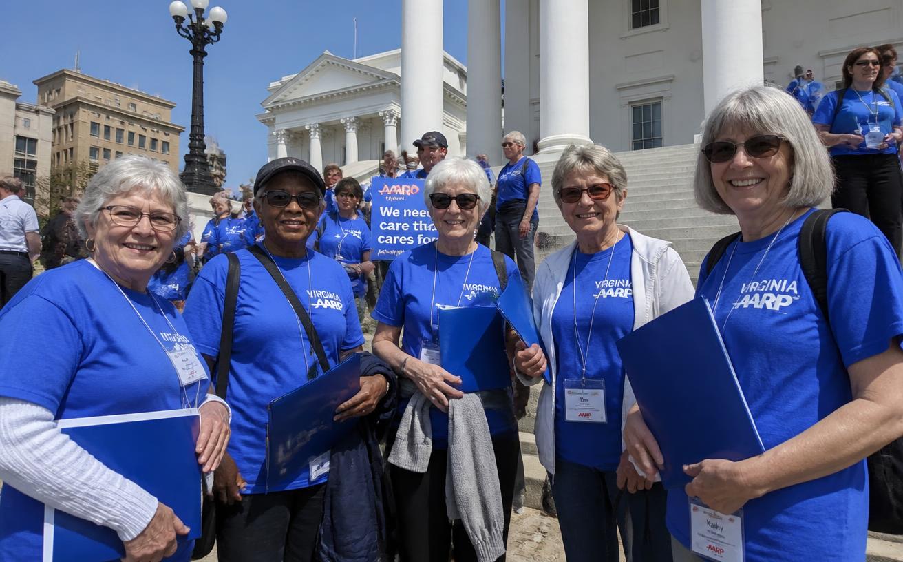 Volunteer advocates in blue shirts on the steps of the Virginia State Capitol.
